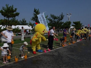 市長とはばたんが打ち水をしている写真